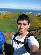 Selfie by Ben Lachman with ocean and green hill in background